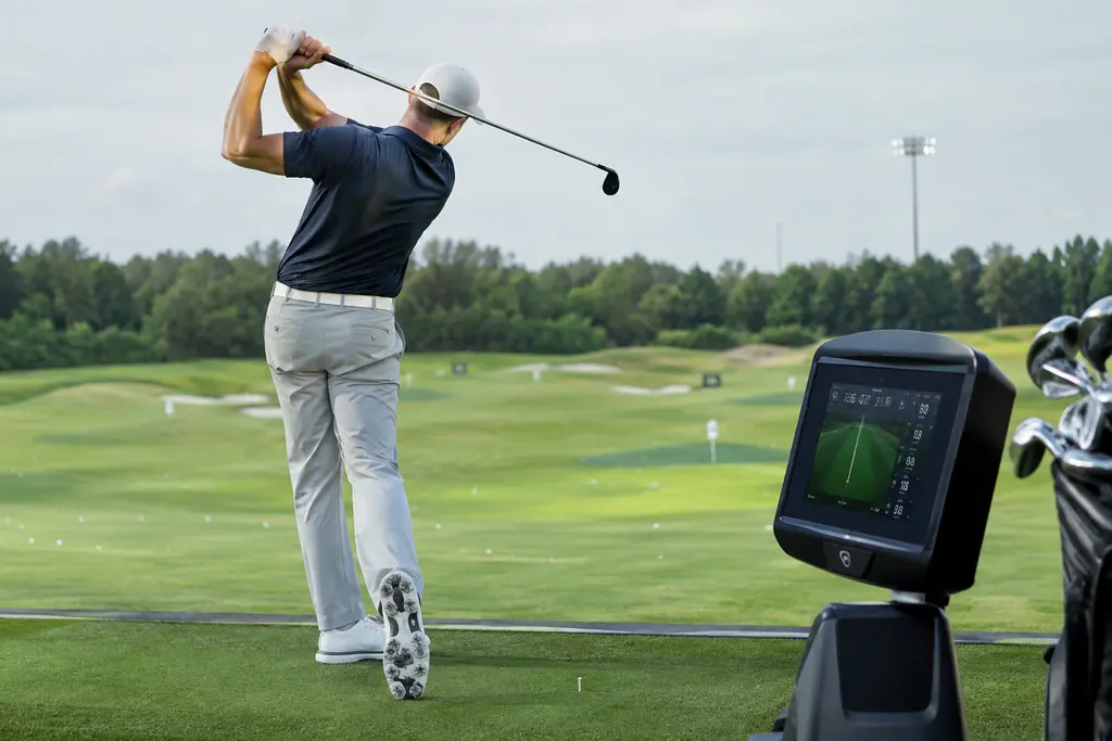 Foresight+ upgrades shown on a simulator screen beside clubs in a fitting bay
